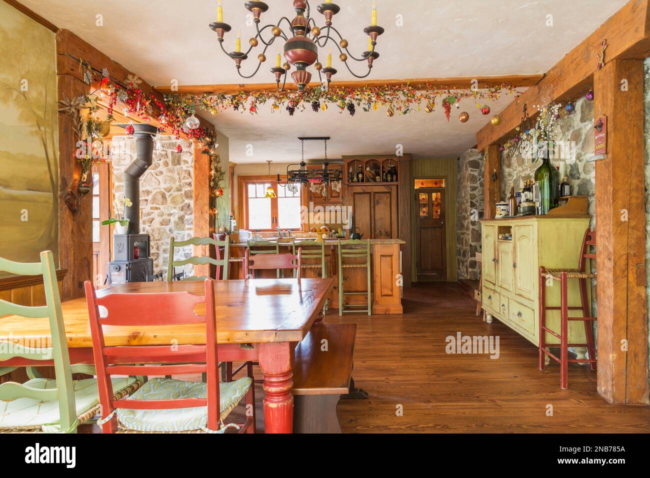 Dining room with antique pinewood table with red stained wooden legs, wood and woven rawhide