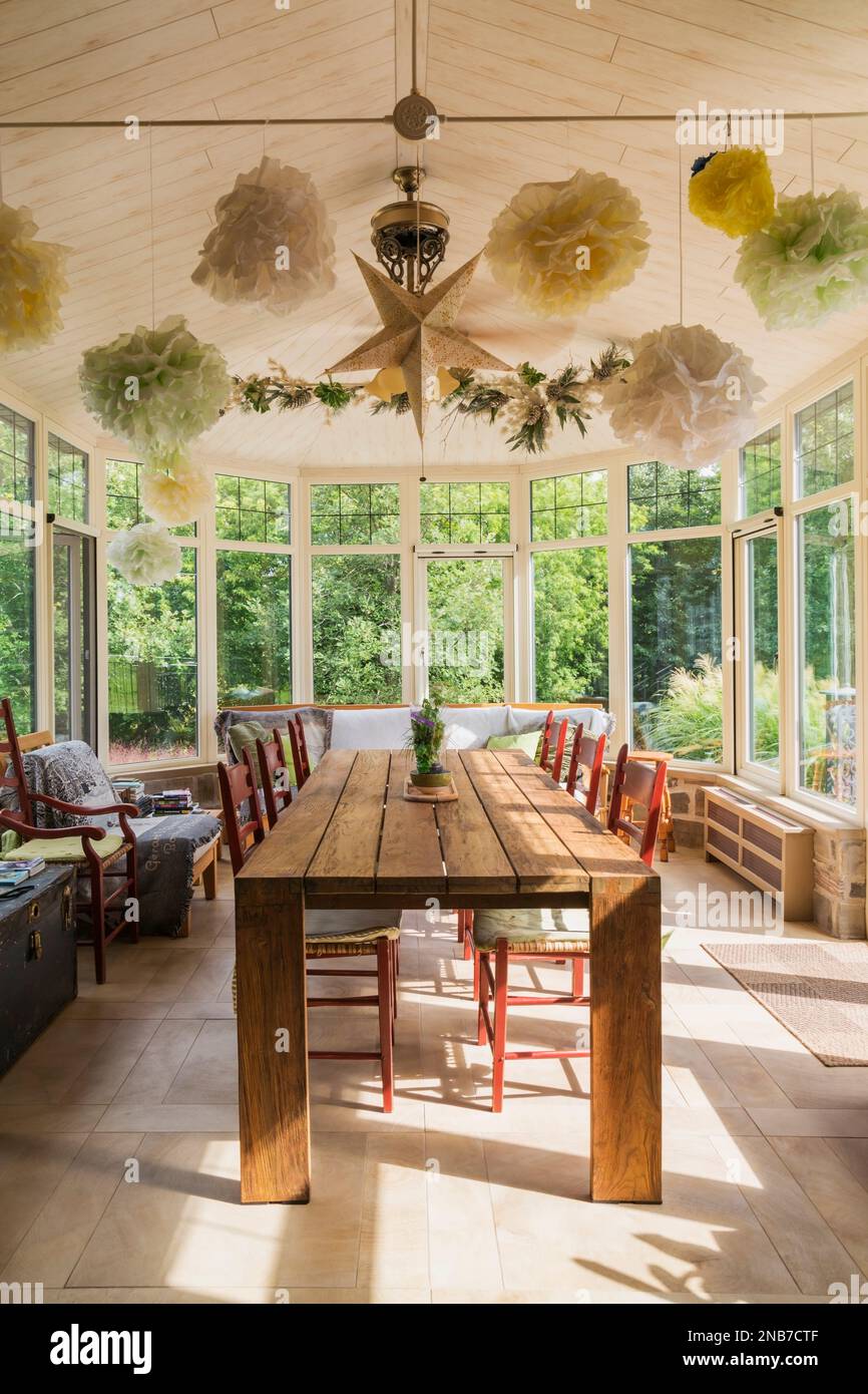 Recycled teak wood dining table with red wood and woven rawhide seat chairs in solarium with wood imitation ceramic tile floor inside old 1826 home Stock Photo Alamy