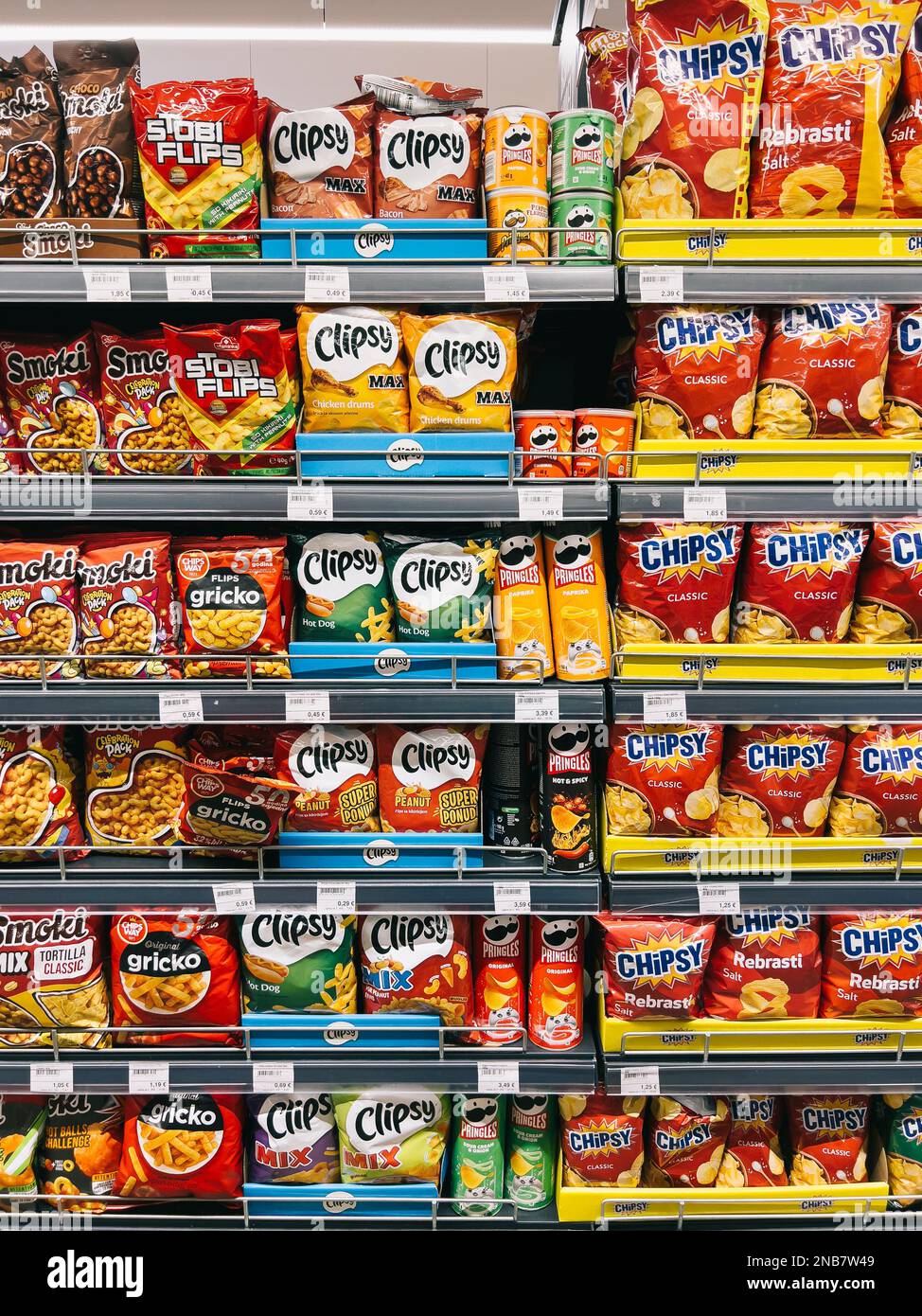 Rows of multicolored packs of chips stand on the shelves in the