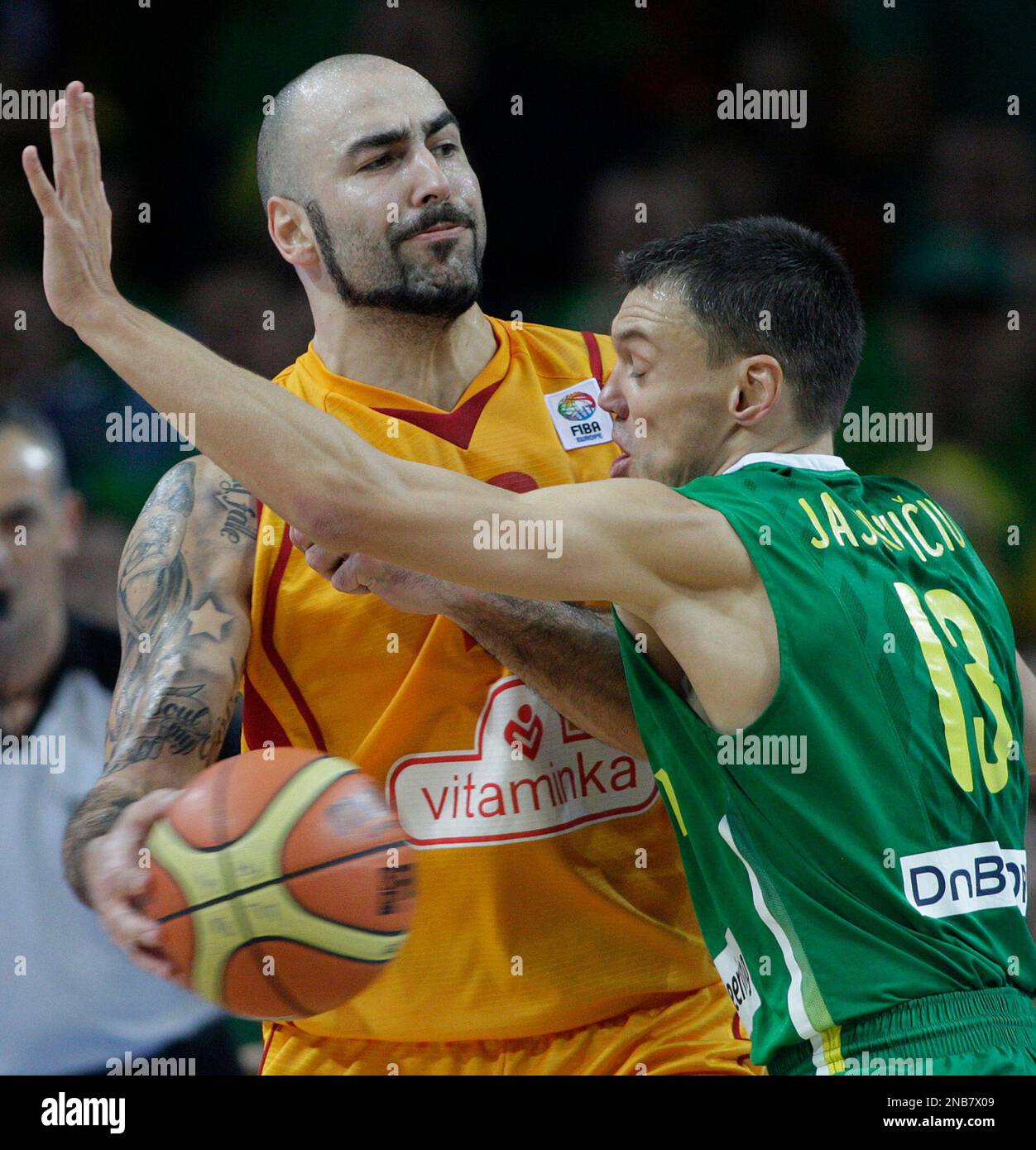 Pero Antic, left from Macedonia is challenged by Sarunas Jasikevicius, right, from Lithuania
