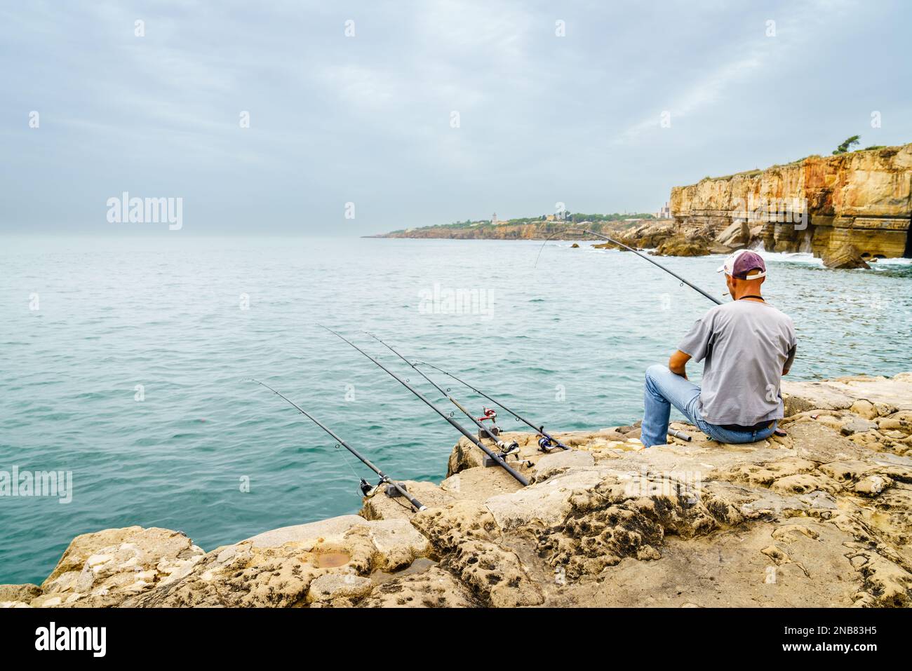 Cascais, Portugal, October 27, 2016: A man is fishing off the clifffy coast near Cascais, Portugal Stock Photo