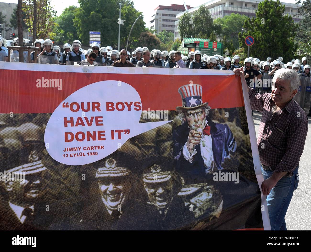 Riot police stand-by as leftist Turks hold a poster of the military ...