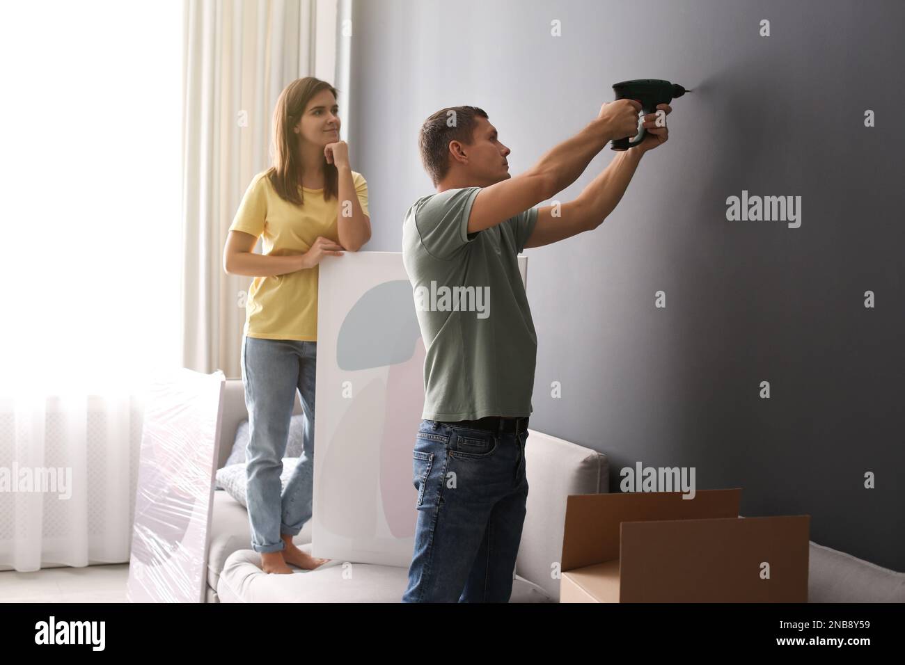 Couple decorating room with pictures together. Interior design Stock ...