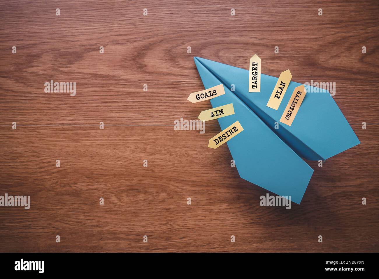 Blue paper plane with sticky notes written with Goals, Aim , Desire