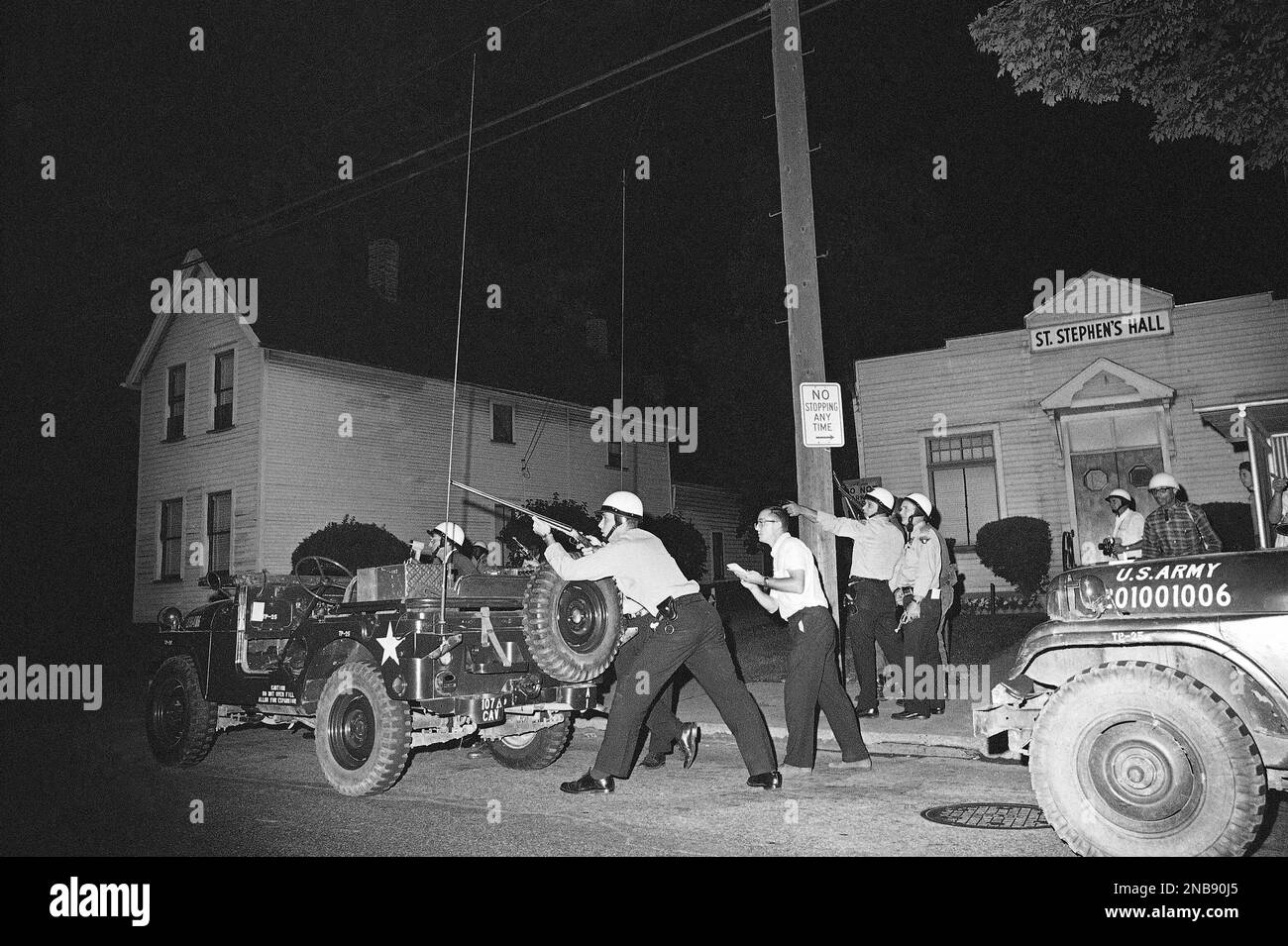 Police and newsmen take cover as they investigate a report of a sniper ...