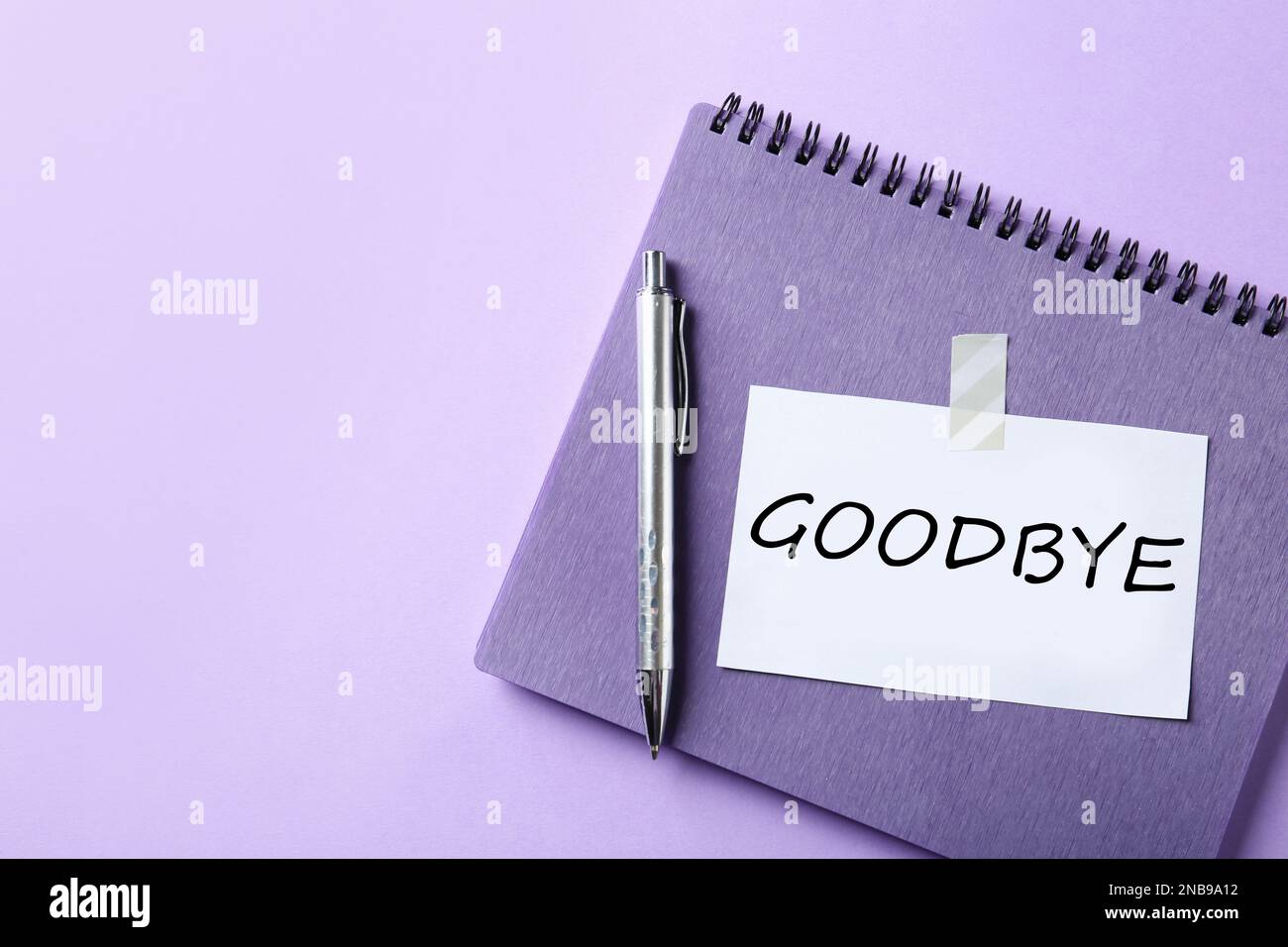 Note with word Goodbye, notebook and pen on violet background, space for text Stock Photo