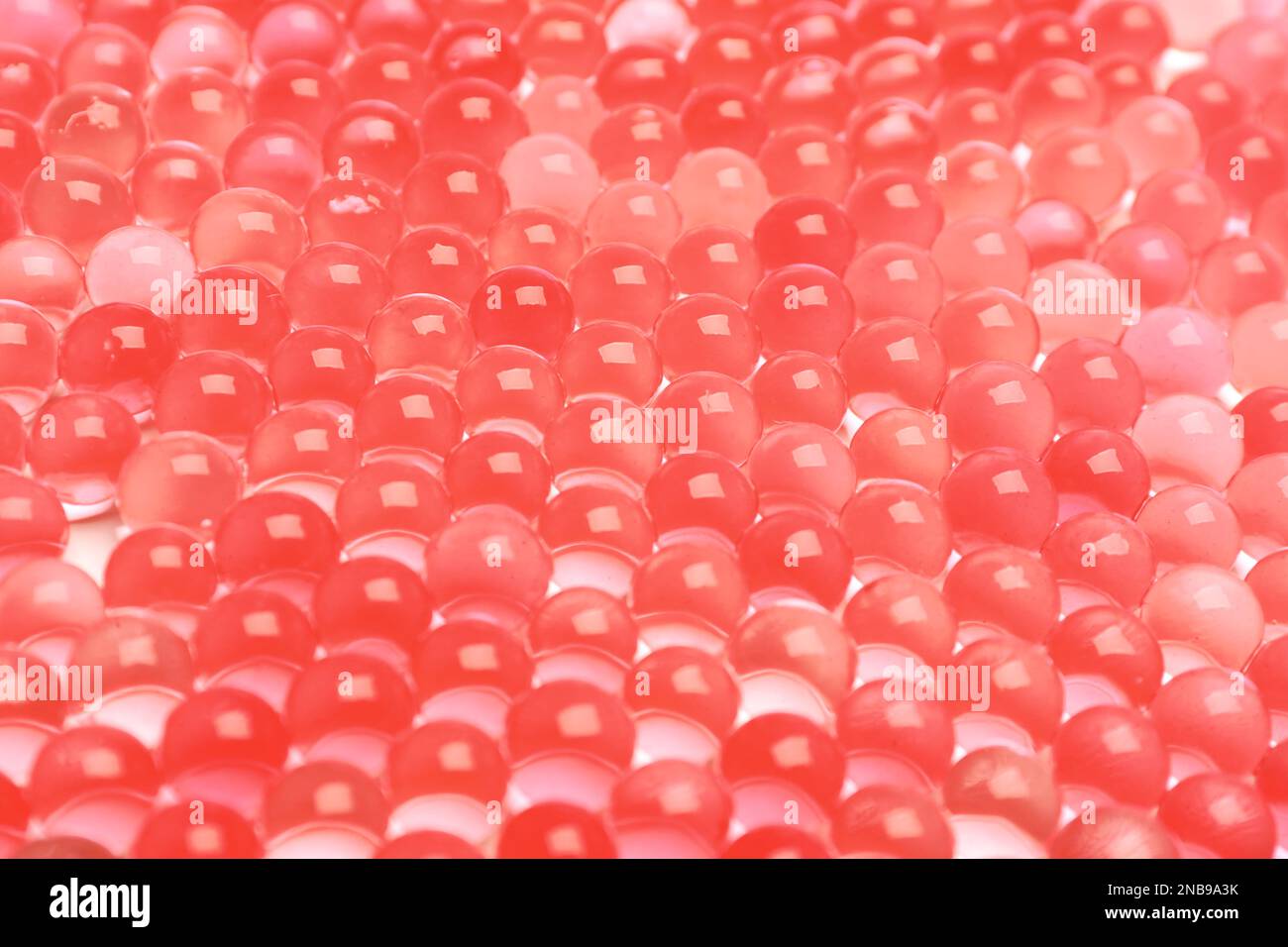 Closeup view of red vase filler as background. Water beads Stock Photo