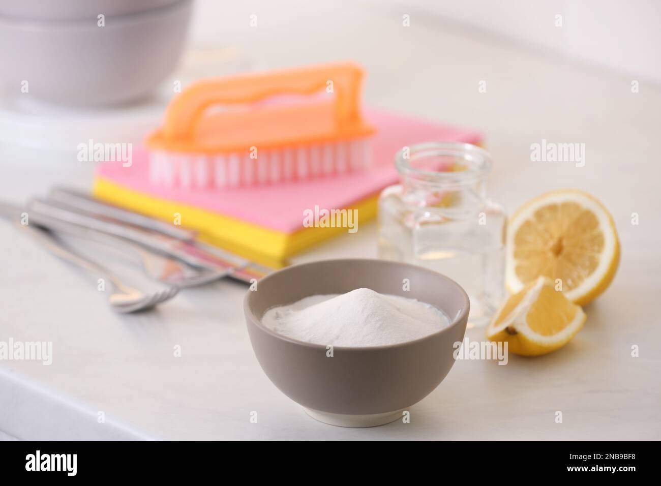 Baking soda, lemon and vinegar on white table. Eco friendly detergents