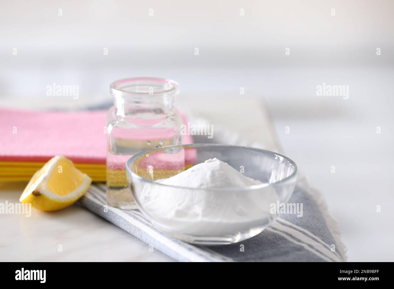 Baking soda, lemon and vinegar on white marble table. Eco friendly