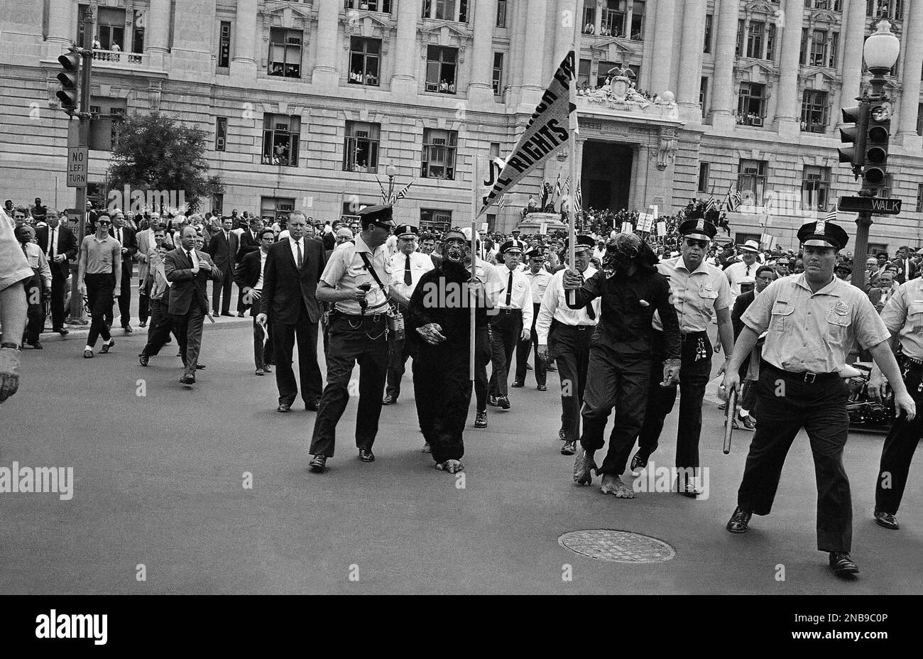 Metropolitan police hustle off two hecklers, dressed as apes, during a