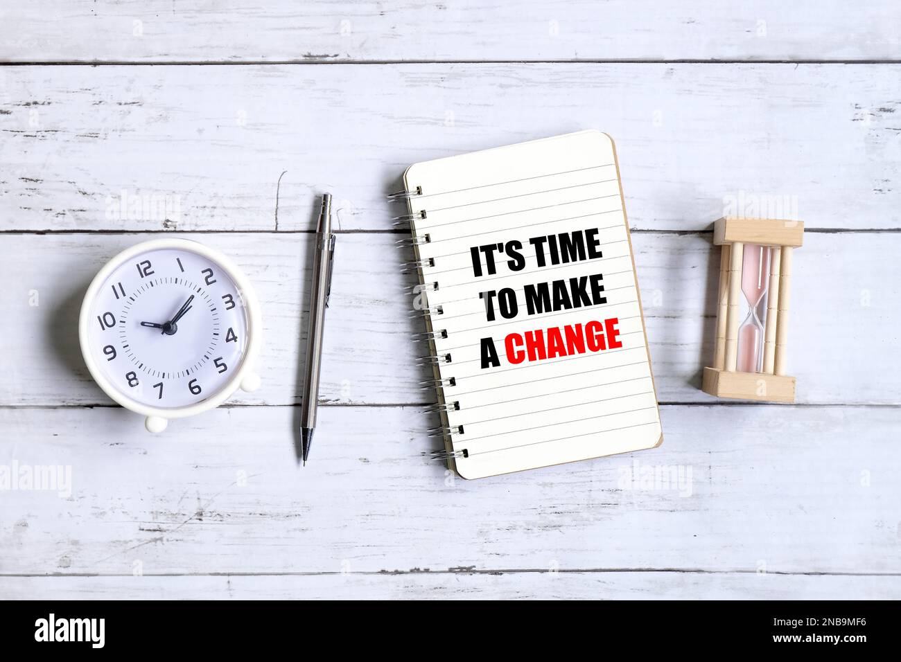 Top view of clock,hourglass,pen and notebook written with inspirational