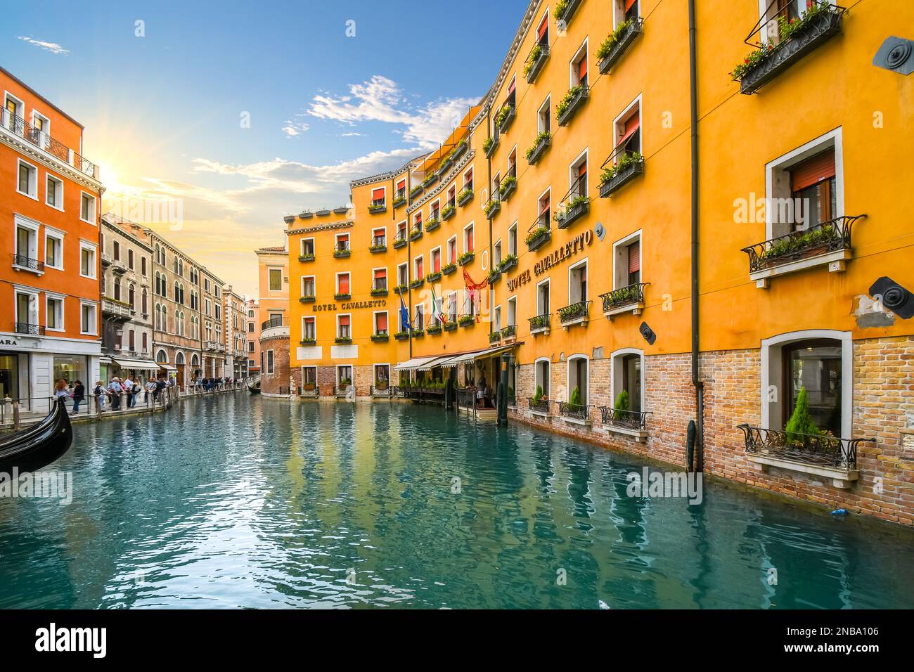 The Orseolo Basin, location of a gondola station, in front of a luxury hotel as tourists enjoy a late afternoon in Venice, Italy Stock Photo