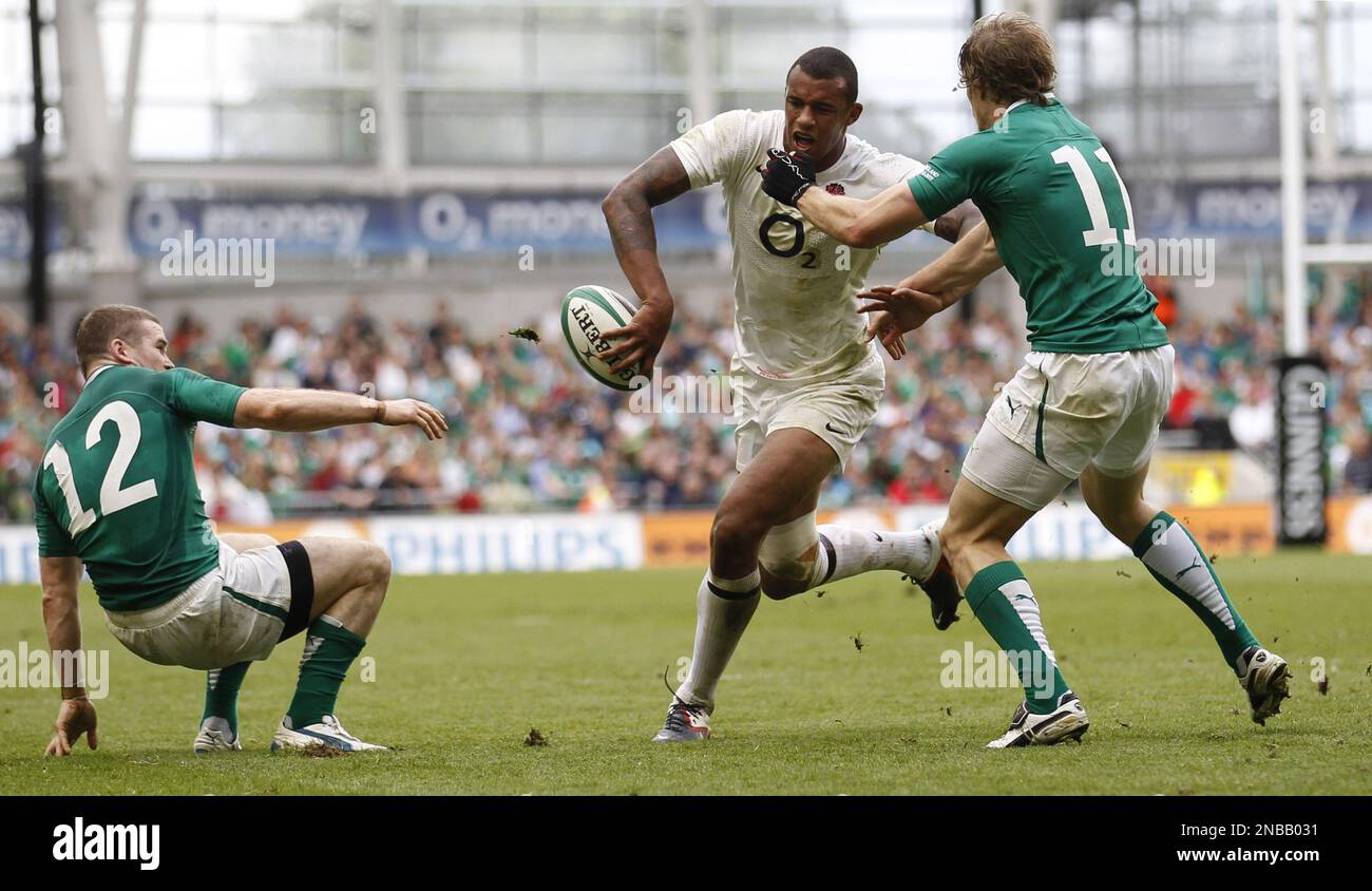 England's Courtney Lawes, center, is tackled by Ireland's Andrew