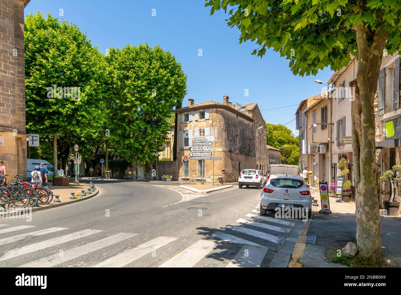 Sign posts pointing towards Avignon, the Alpilles and the tourism office at an intersection in the medieval center of Saint-Remy-de-Provence, France Stock Photo