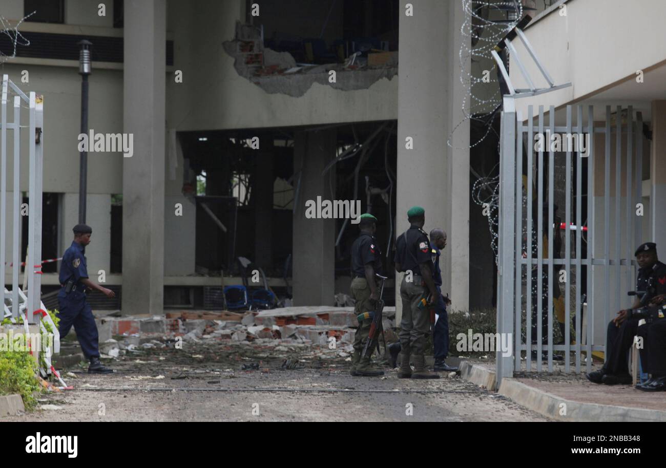 Nigerian policemen patrol the site of a large explosion attack on the ...