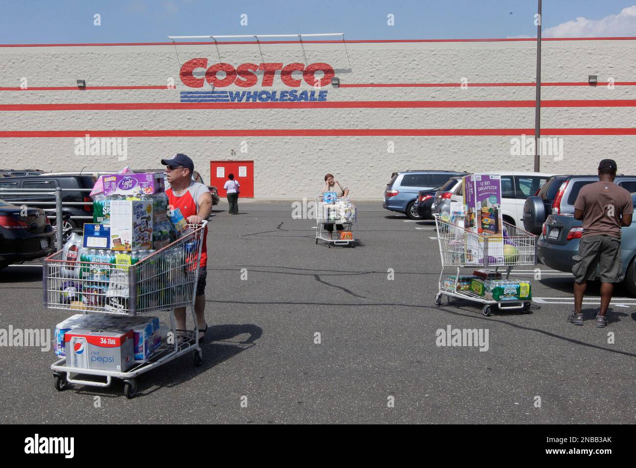 People load their cars with food and water in the Costco parking lot