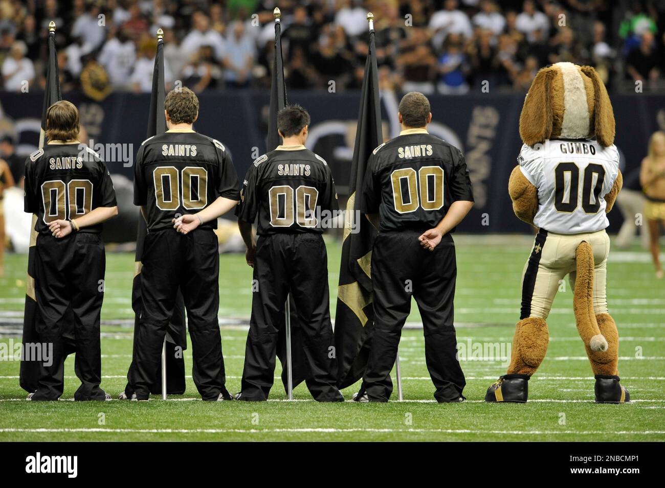 New Orleans Saints cheerleaders and Gumbo the mascot stand at attention ...