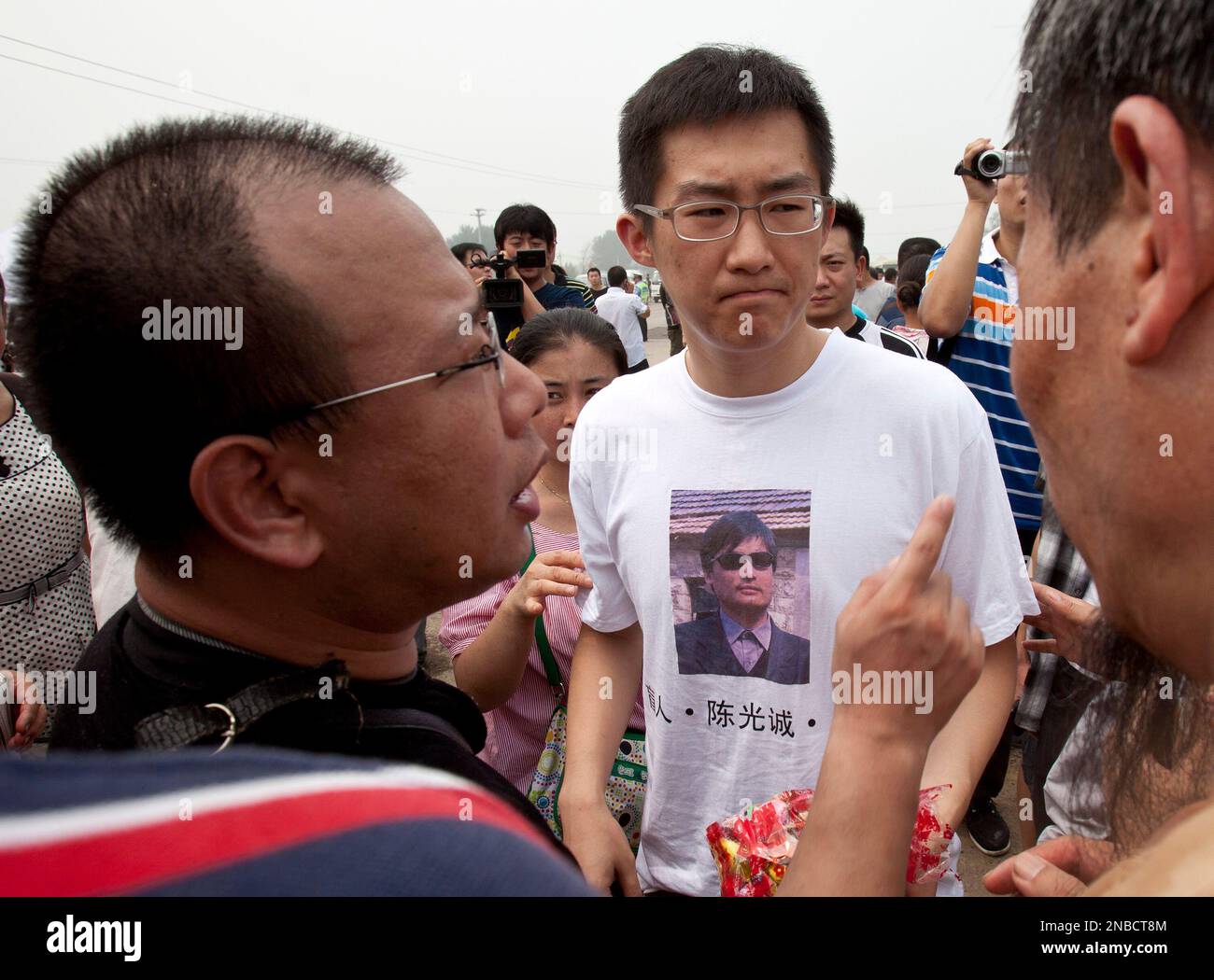 Qi Jianxiang, center, son of Wang Lihong, chats with Zhao Lianhai, left, an activist previously jailed for protesting a massive tainted milk scandal, outside the Wenyuhe People's Court in Beijing, China, Friday, Aug. 12, 2011. Wang, a Chinese activist known for pushing legal issues and backing a jailed Nobel peace laureate went on trial Friday on a vaguely worded charge, reinforcing Beijing's sweeping crackdown on dissent. (AP Photo/Andy Wong) Stock Photo