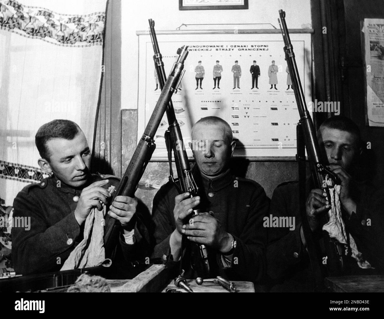 These polish frontier guards cleaning their guns in front of a guide to
