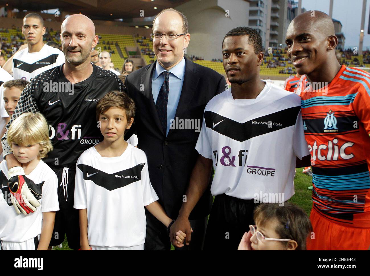 Prince Albert II of Monaco, poses with former goalkeeper Fabien Barthez of France, left, Manchester United player Patrice Evra, second from right, and Marseille player Charles Kabore before a charity match between Olympique Marseille soccer team and a Manchester United team Tuesday, Aug. 2, 2011, in Monaco stadium. (AP Photo/Lionel Cironneau) Stock Photo