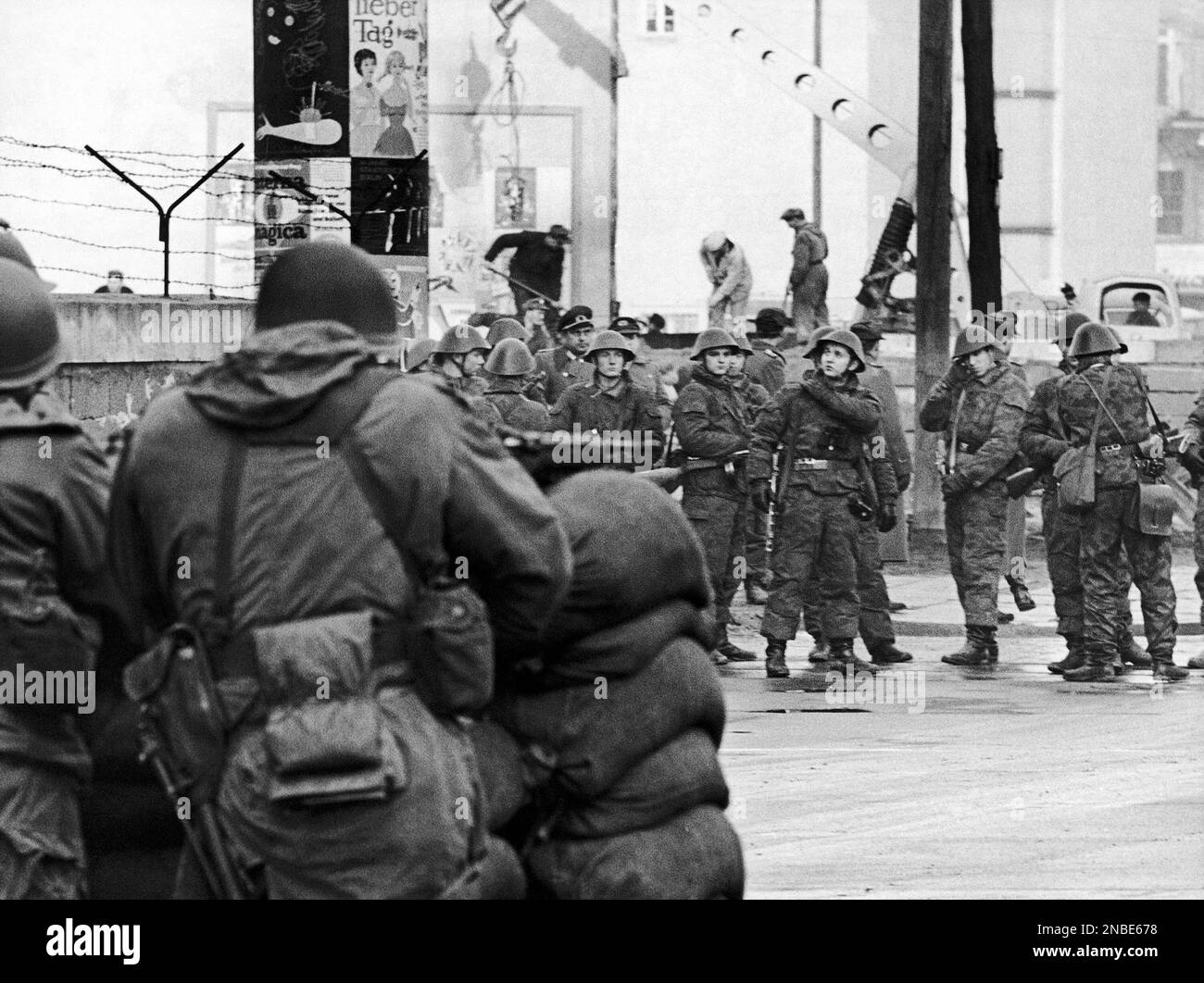 US soldiers with automatic rifles in the foreground left, watch East ...
