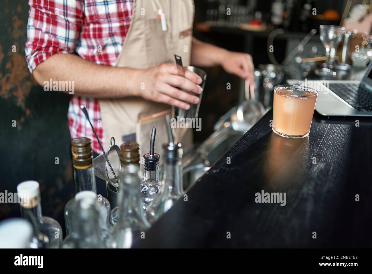 bartender pouring a cocktail from a shaker into a glass Stock Photo Alamy
