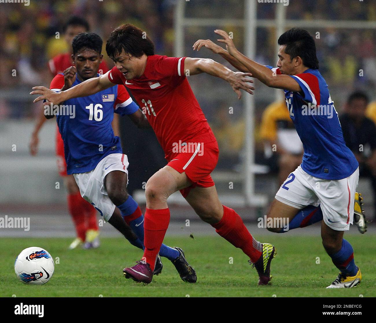 Singapore's Qiu Li, center, is challenged by Malaysia's Kunanlan ...