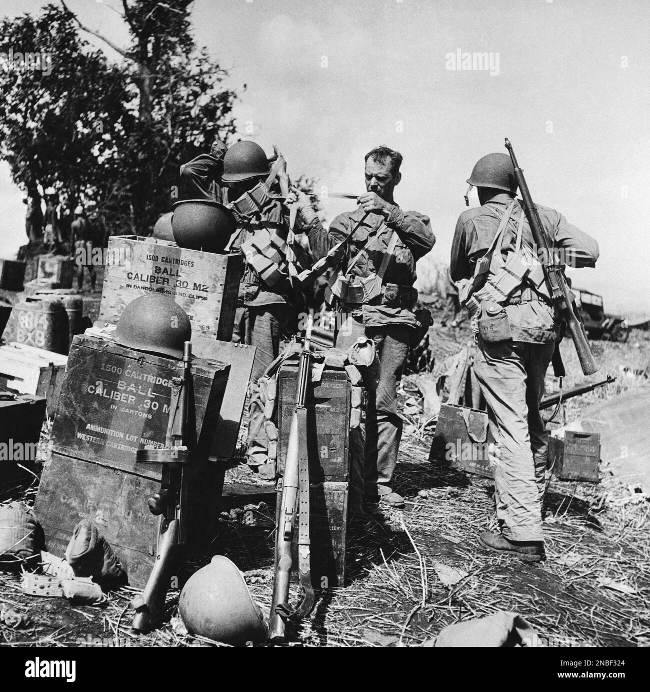A U.S. soldier helps a buddy put on a bandolier of ammunition for
