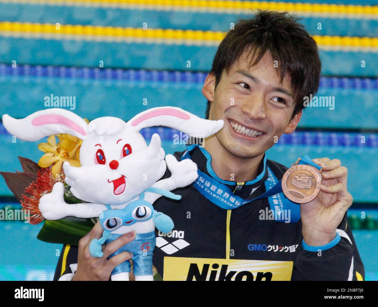 Japan's Ryosuke Irie holds up his bronze medal for the men's 100 meters