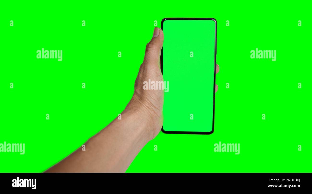 hand holding a green smartphone on a green background Stock Photo - Alamy