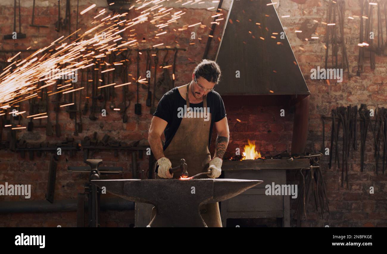 Sparks fly when I do what I love most. a metal worker hitting a hot