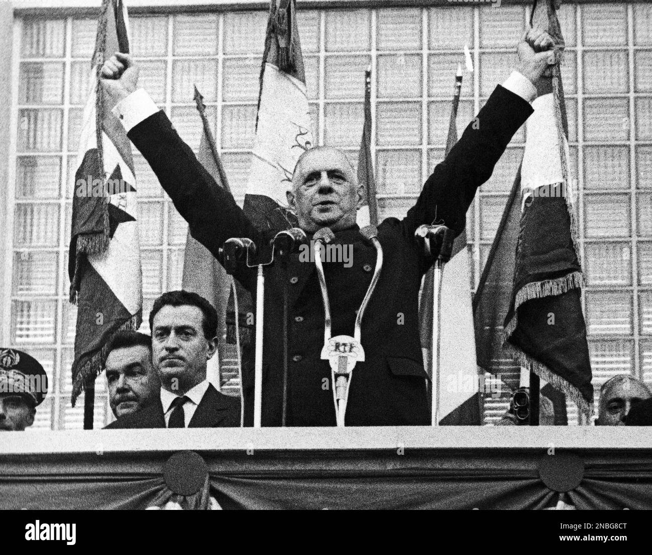French President Charles de Gaulle, raises his arms during his
