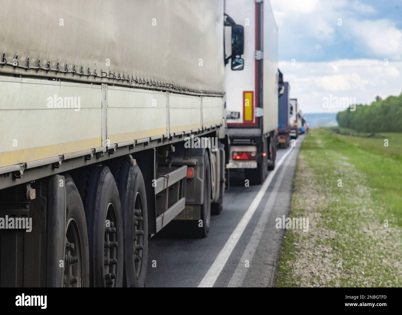 Trucks are stuck in traffic. A column of semitrailers on the freeway