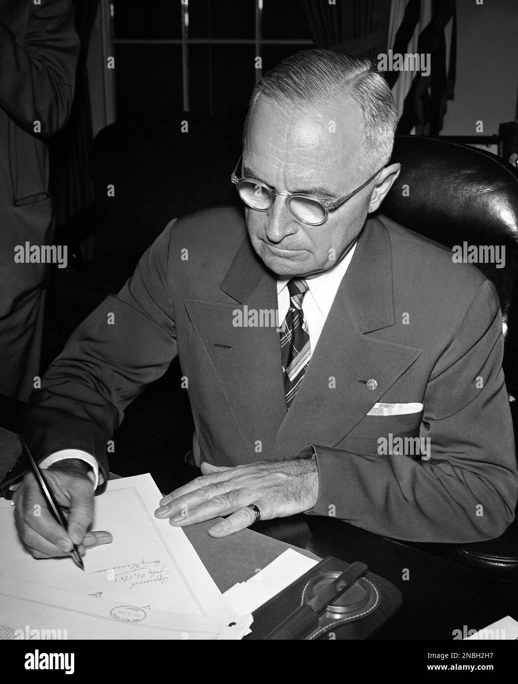 President Harry Truman signs the new economic control bill in