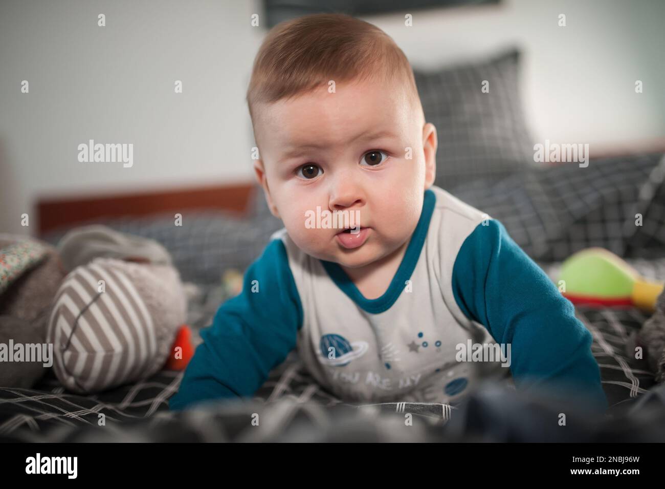 Cute baby boy lies on its stomach and crawls. Joy and happiness concept