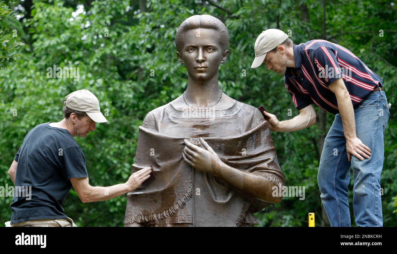 Noel Ward, left, and Mark Erdmann restore a bronze statue of Larisa