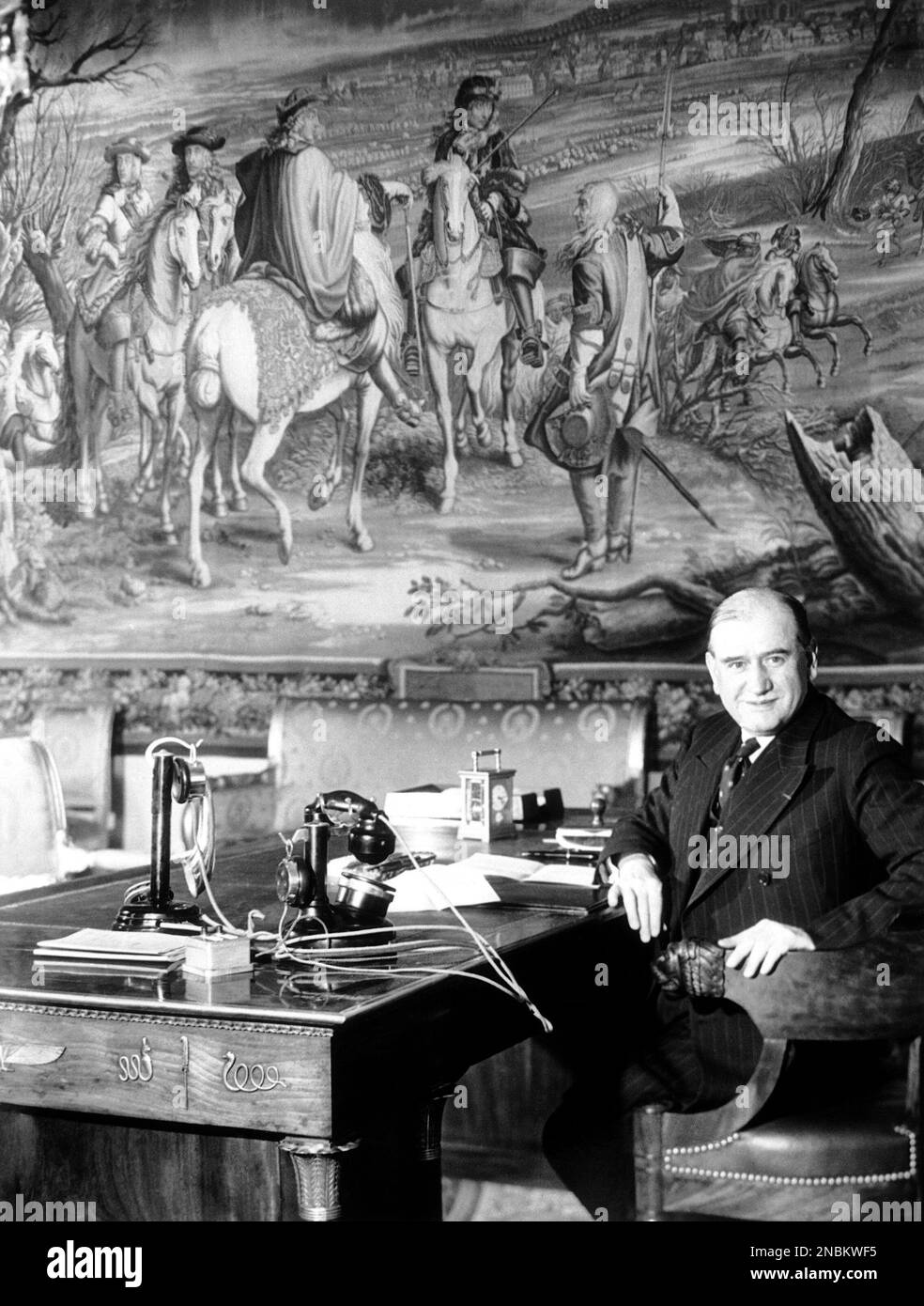 French Prime Minister Edouard Daladier,at his desk in Paris on March 29, 1939. On the wall behind is seen a Gobelin tapestry of Louis XIV winning the Battle of Dole. (AP Photo) Stock Photo