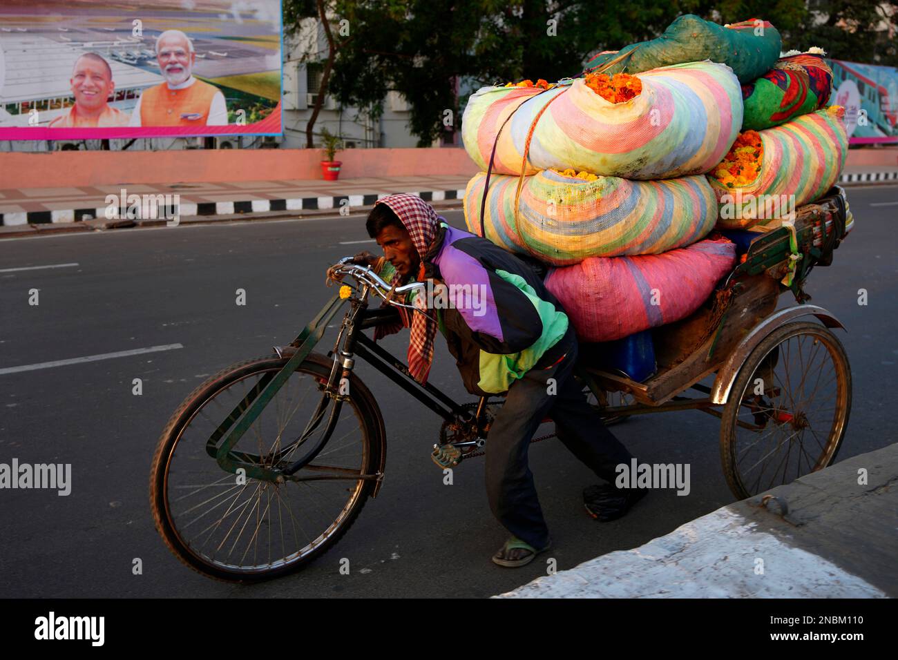 A rickshaw puller transports flowers to a wholesale market early
