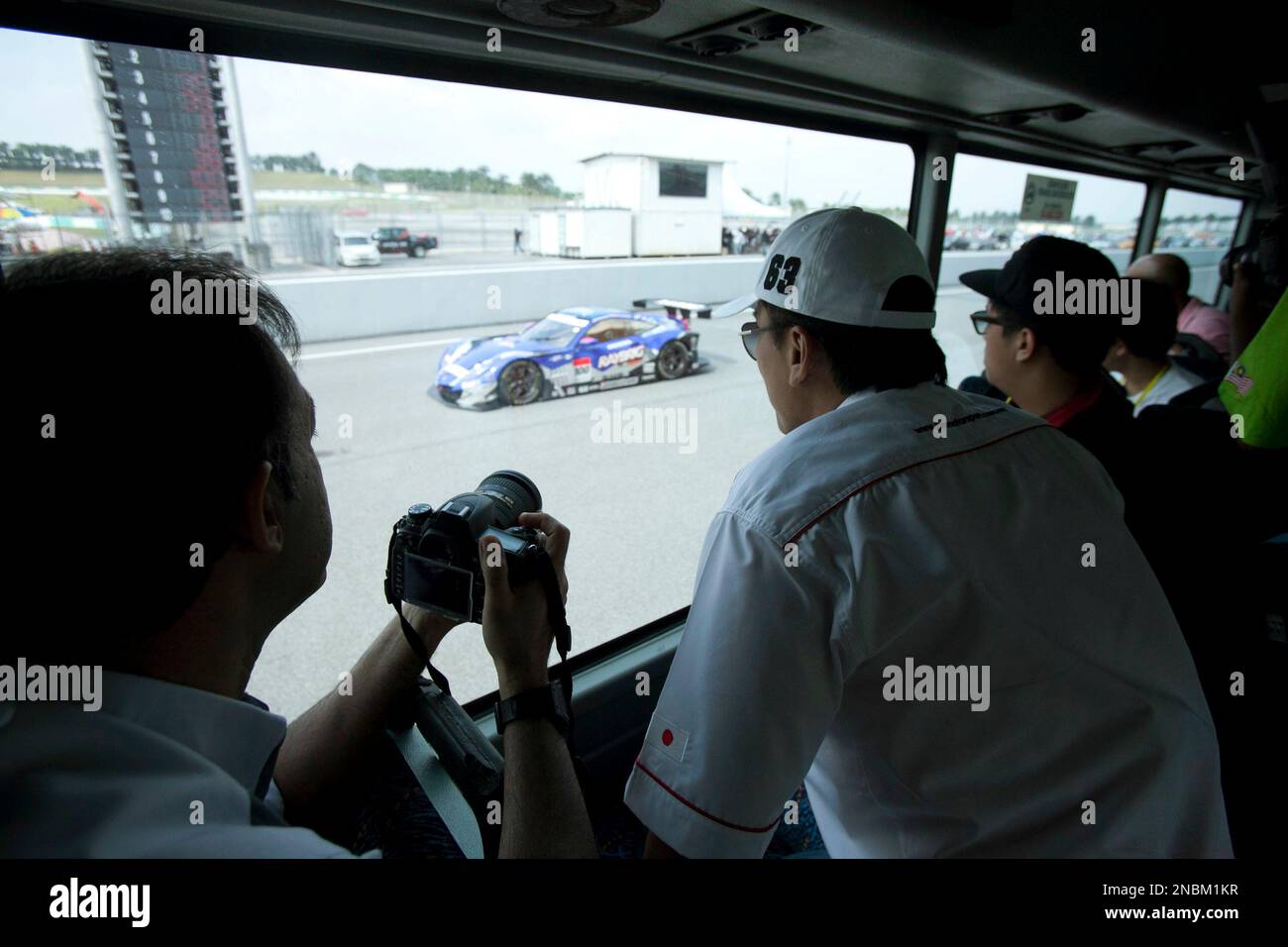 Auto racing fans watch Japan GT race cars from a bus during the Japan ...