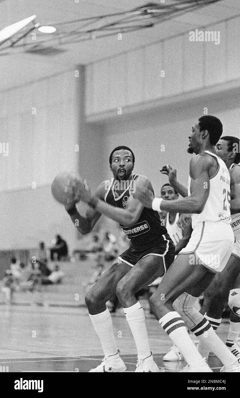Former National Basketball Association star Marvin Barnes, in dark uniform,  playing for the New Jersey Nets, looks for shooting room around Detroit  Pistons Edgar Jones (25) during game of the Summer Pro