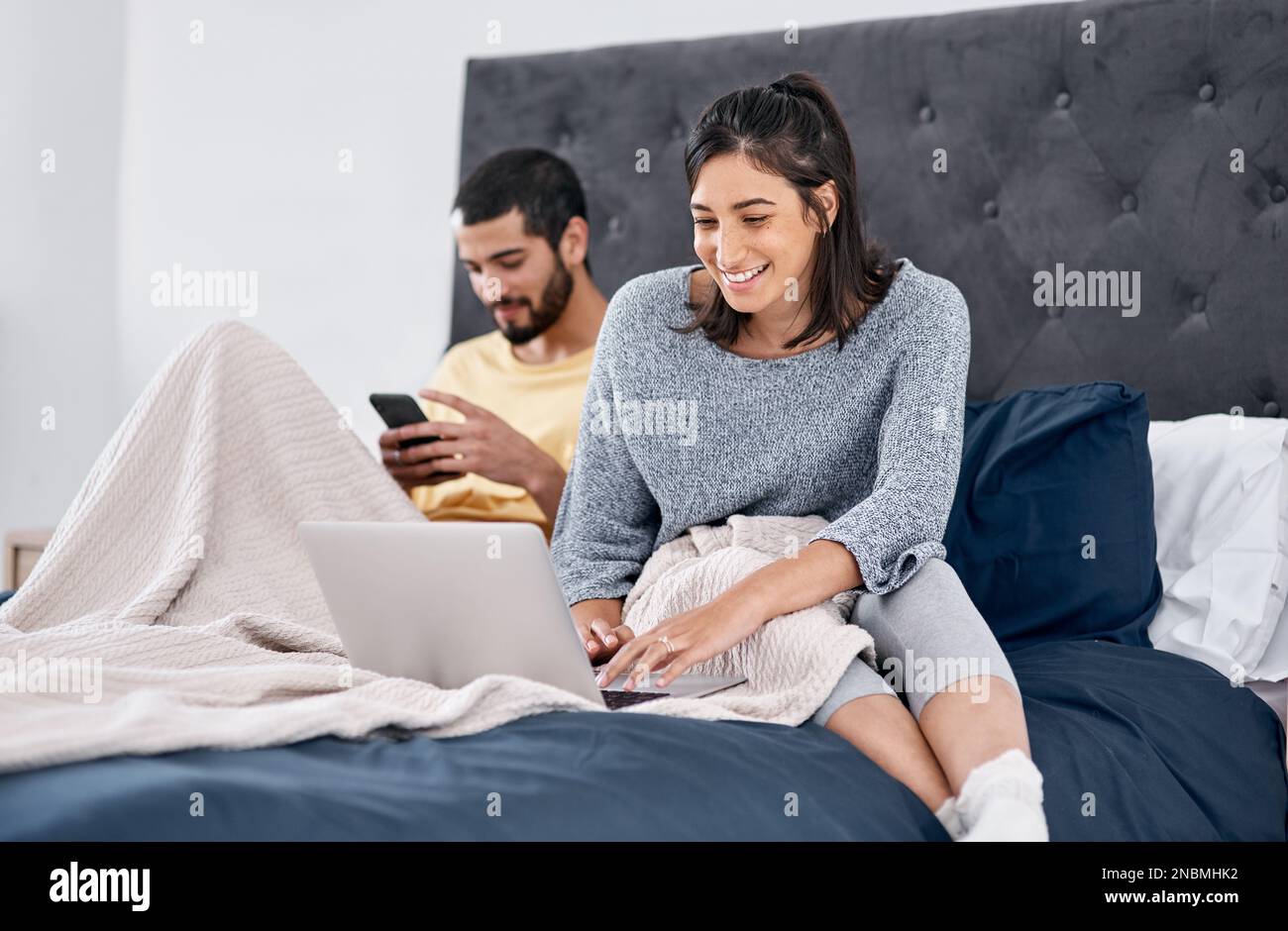 Connecting in quarantine. a young couple using their wireless devices