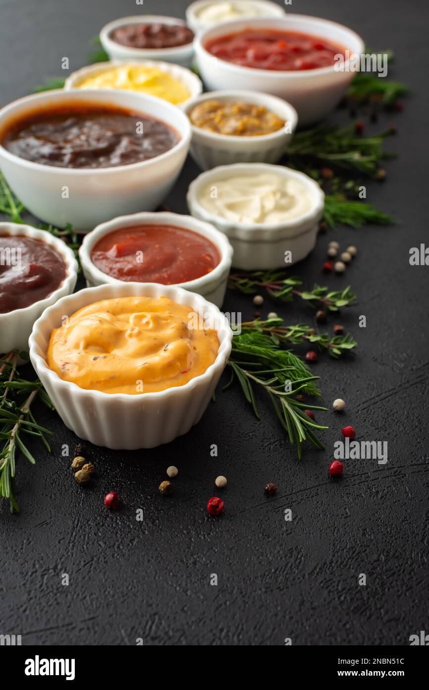 Different types of sauces in bowls with seasonings, rosemary and dill