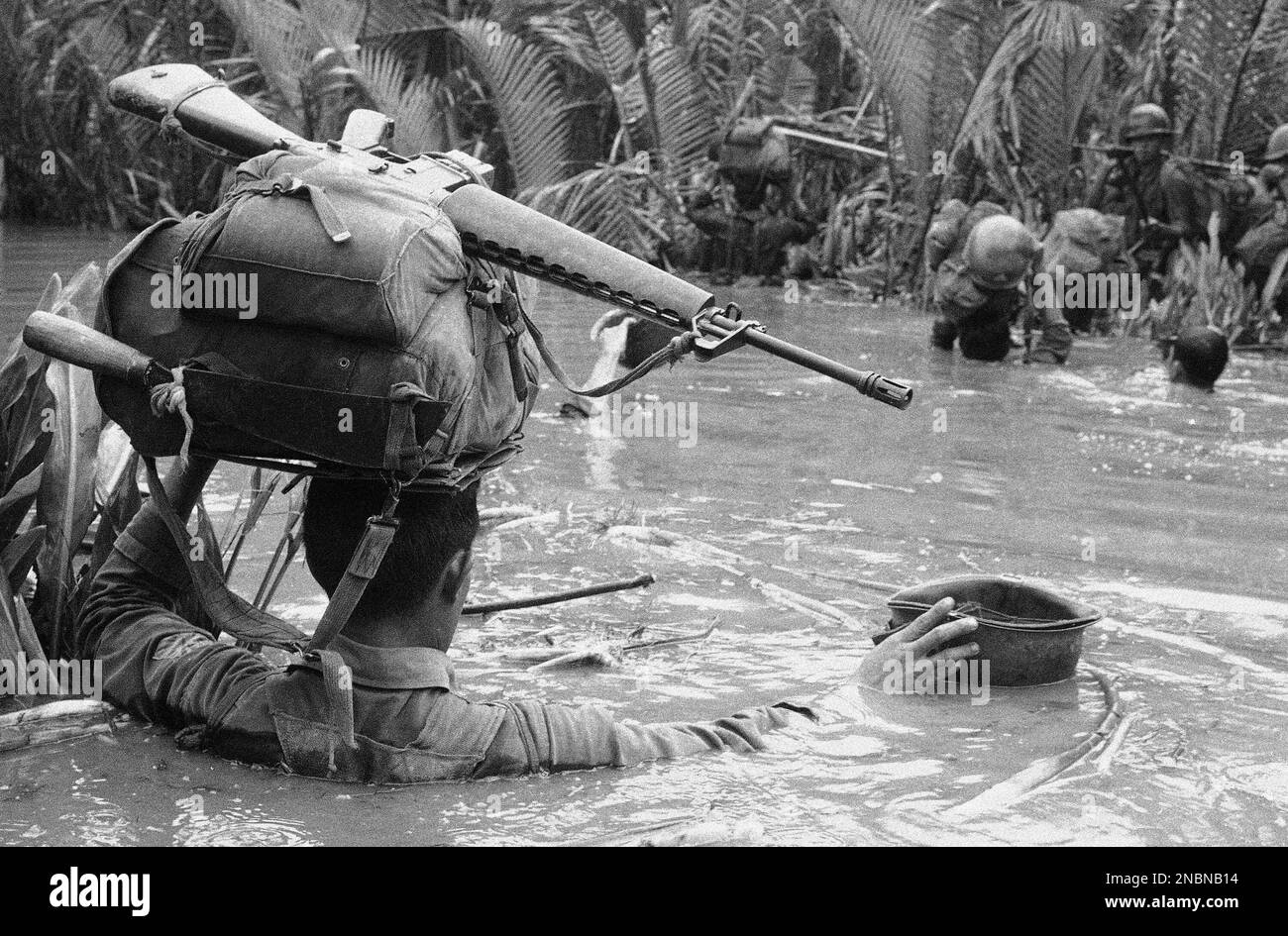 A South Vietnamese soldier prepares to float his helmet across the muddy Mekong Delta at Camau