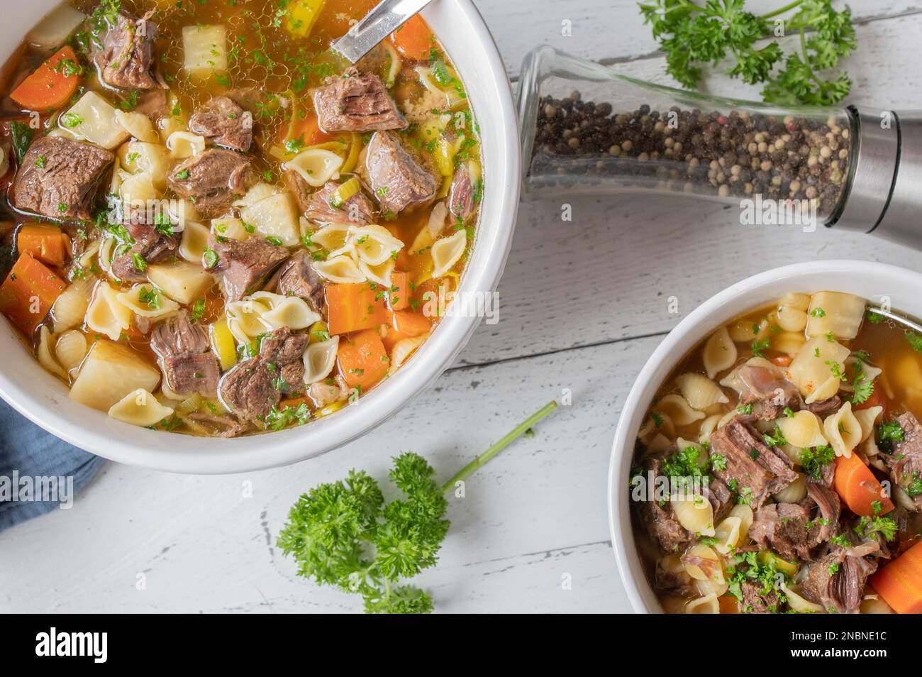 Beef noodle soup with clear broth, root vegetables and pasta in a bowl