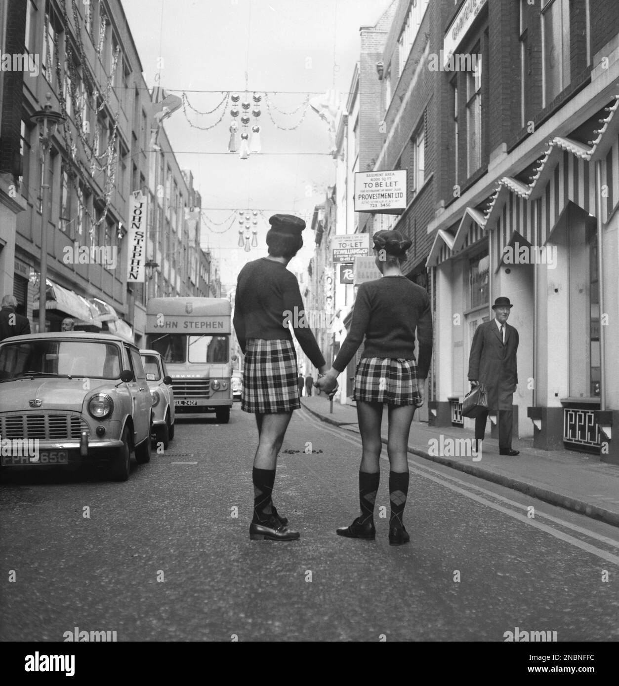 A man and woman posing in identical outfits of jumper and skirt in fashionable Carnaby Street, London 1968.   Photo by Tony Henshaw Archive Stock Photo