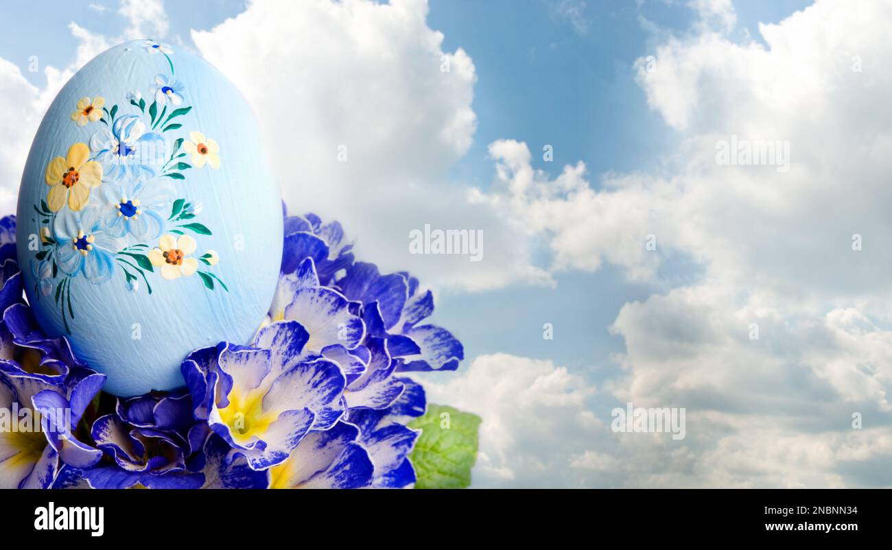 decorated blue Easter egg and spring flowers Stock Photo