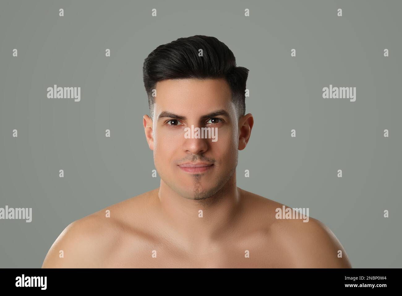 Handsome man with half shaved face on grey background Stock Photo
