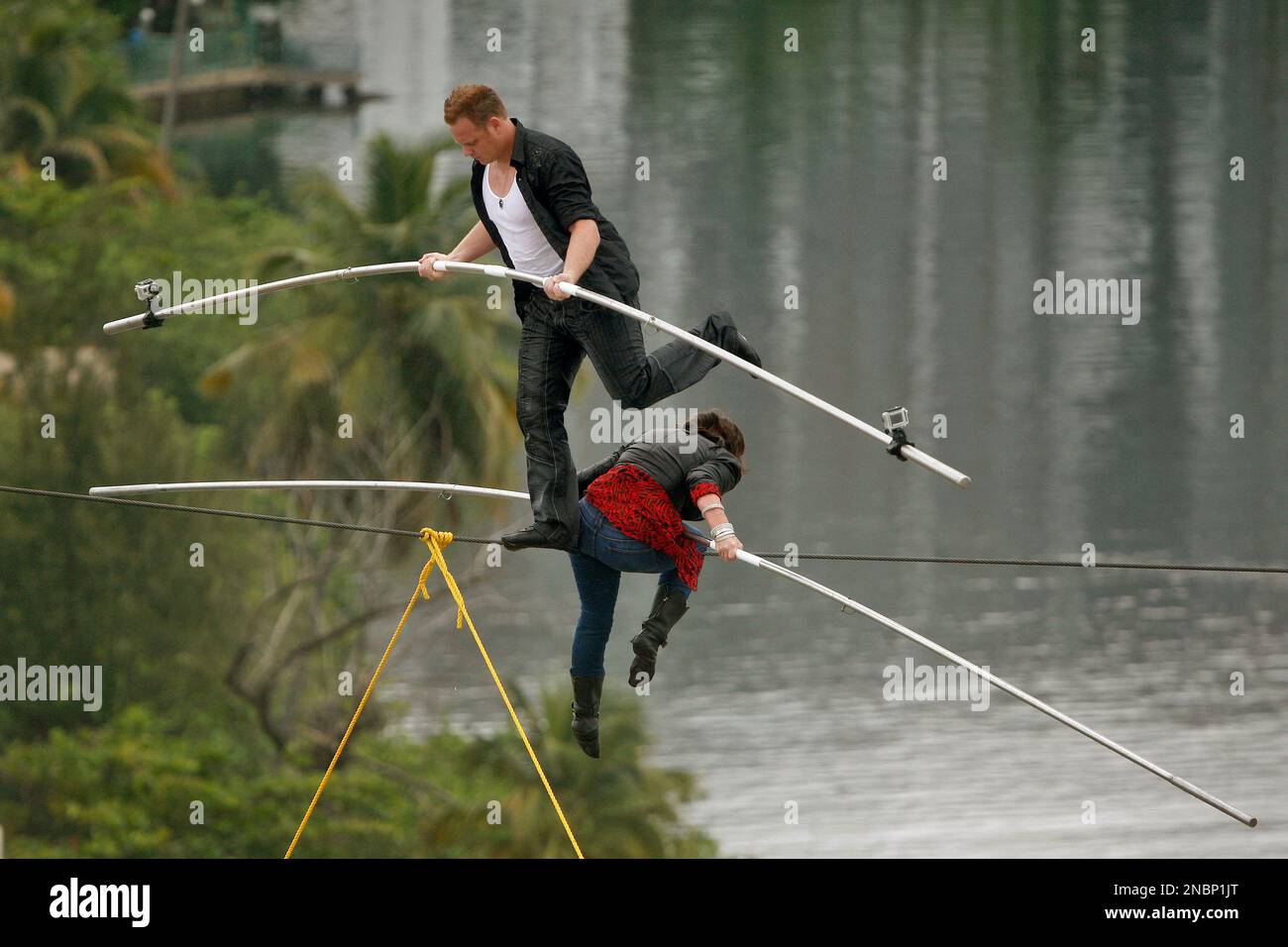 Highwire acrobats Delilah Wallenda, right, lowers her head as her son Nik Wallenda, left