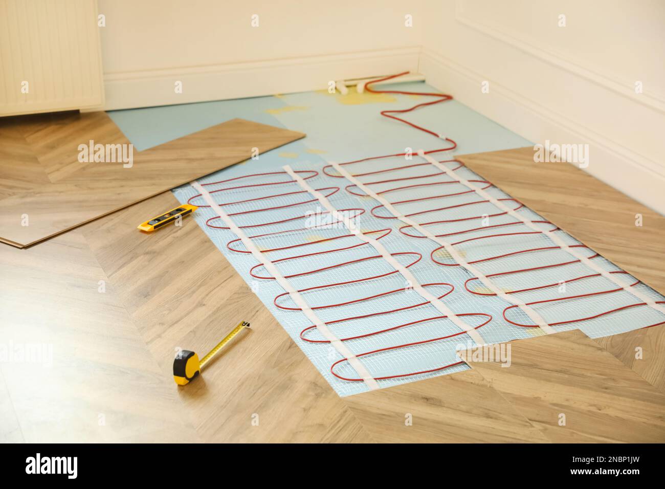 Installation of electric underfloor heating system indoors Stock Photo