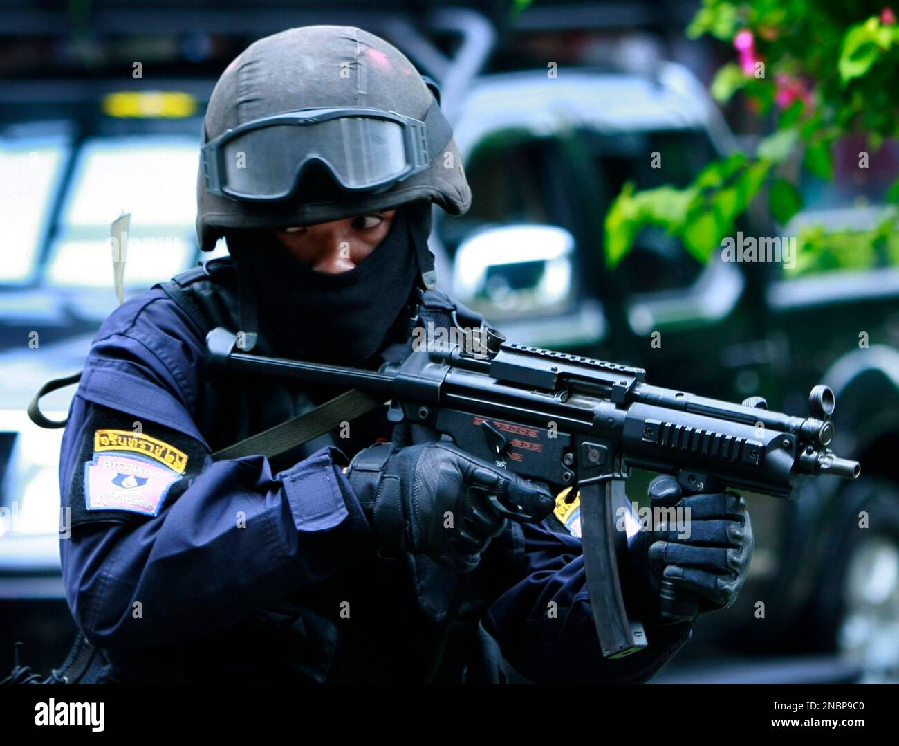 A Thai police commando takes a position to protect his fellow officer ...